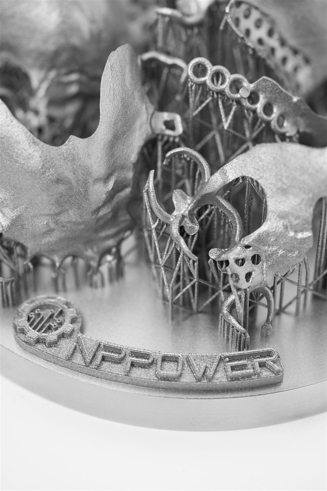 Close-up of printed metal partial denture frameworks on a build plate with NPPOWER lettering